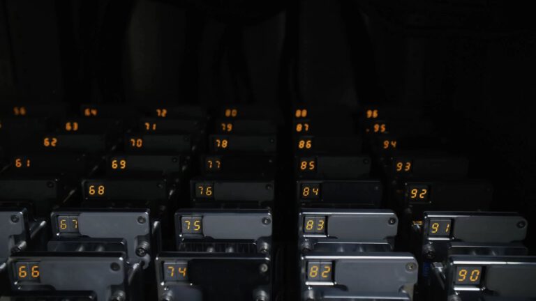 Rows of numbered battery cell test channels in an automated lab